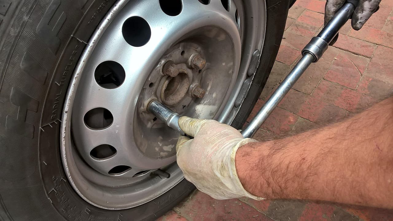 Wheel nuts being tightened on a car wheel